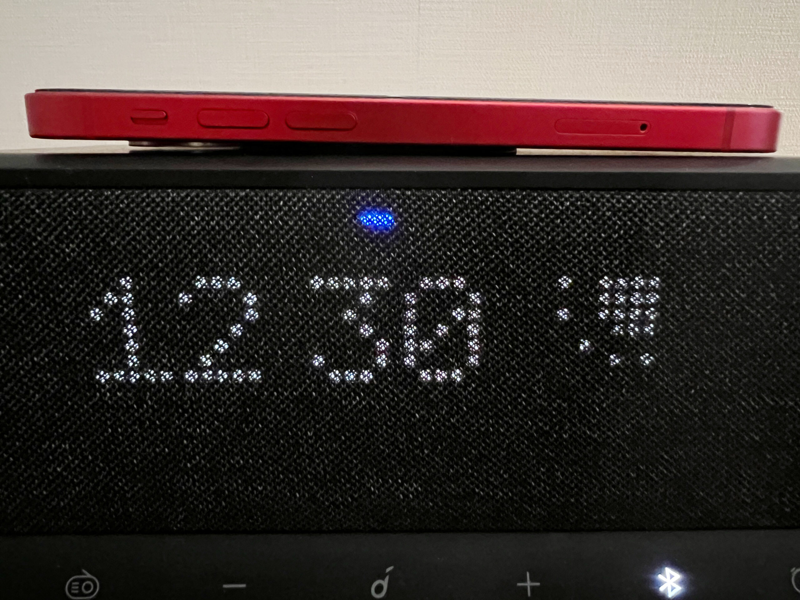 Anker Soundcore Wakeyの上部でiPhone12 miniをQi充電中に光る前面の青いLED表示